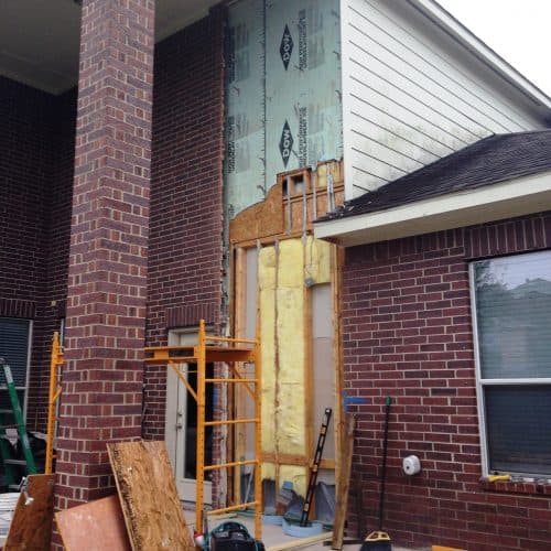 demolition of exterior wall cladding to prepare to install an exterior home elevator shaft