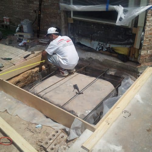 pit construction and start of framing for an exterior shaft for a traditional hydraulic elevator retrofit for a home
