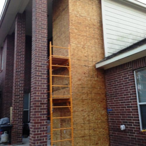exterior slab elevator shaft in phase of being closed in for a 2-story brick home