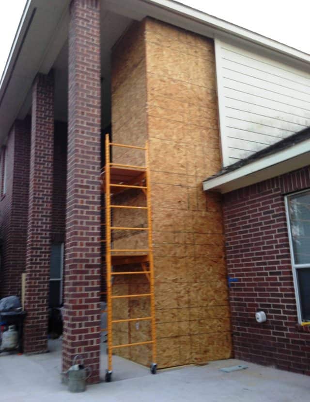 exterior slab elevator shaft in phase of being closed in for a 2-story brick home