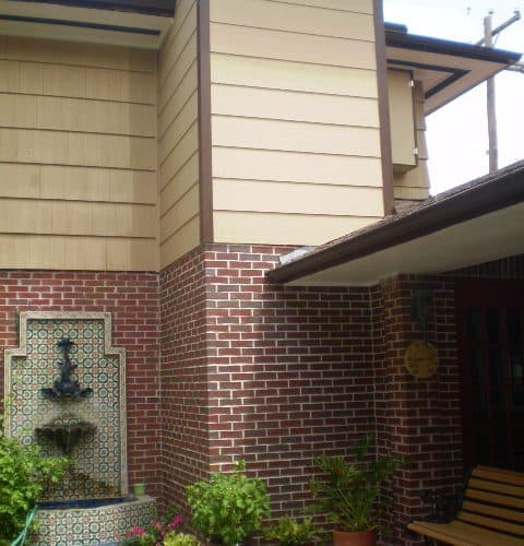 home elevator exterior shaft construction with brick and clapboard facade blends seamlessly with original architecture