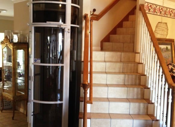 light gray framed vacuum elevator installed beside stairwell of a houston home