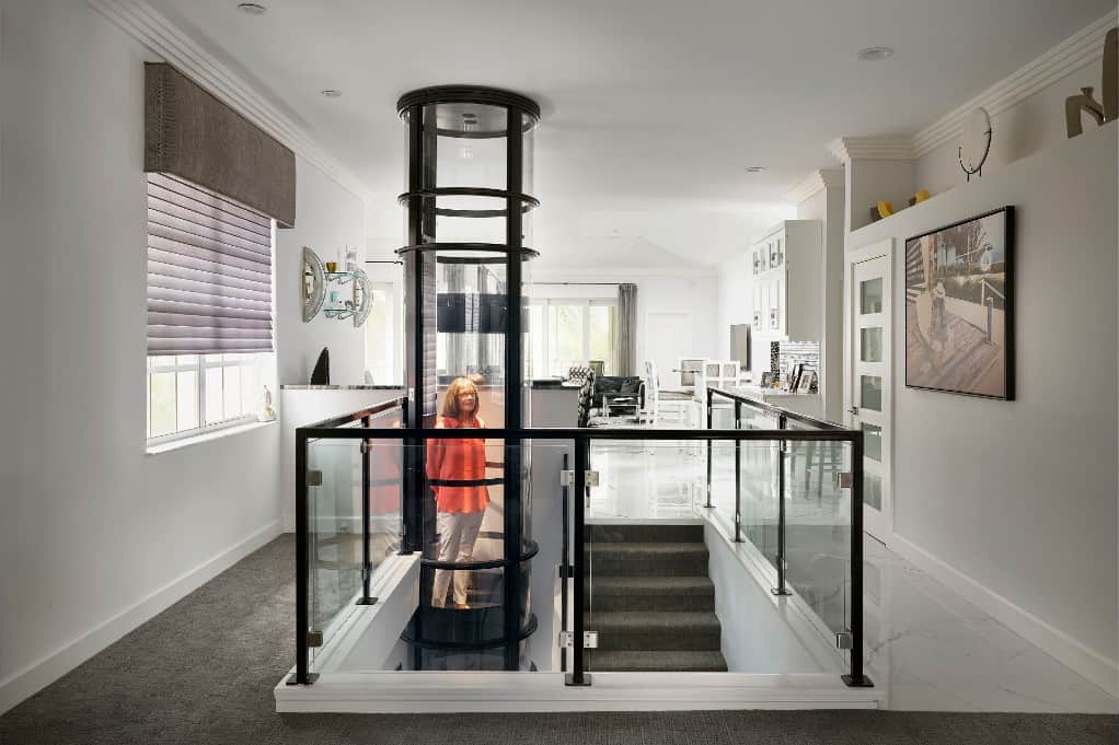 woman riding a pve37 2-person elevator in a modern home